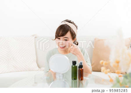 家で笑顔で鏡を見る女性（目・コンタクトレンズ） 95985285