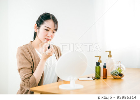 口紅・リップを塗る女性(困る) 口紅・リップを塗る女性(困る) 95986314