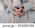 Gel nail design.Beautiful manicure. Nail polish is applied to the hand, polish is a blue color. Blue background closeup. Multi-colored blue manicure. 95986596