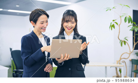 ノートパソコンを見る二人の女性会社員 95988634