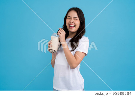 Asian girl holding a cup of pearl milk tea With a smile Asian girl holding a cup of pearl milk tea With a smile 95989584