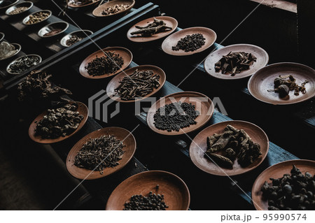 Various spices displaied on small ceramic and metal plates on black wooden background 95990574