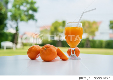 Orange juice and orange halves on the natural background. Orange juice and orange halves on the natural background. 95991857