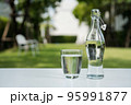 A glass of clean drinking water and a water bottle. 95991877