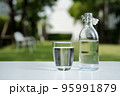 A glass of clean drinking water and a water bottle. 95991879