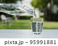 Pour the water from the water bottle into the glass. 95991881