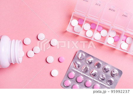 Beautiful closeup of tablet vitamin for women on pink background . Medical healthcare pillbox for a week. Medicine medical health.  95992237
