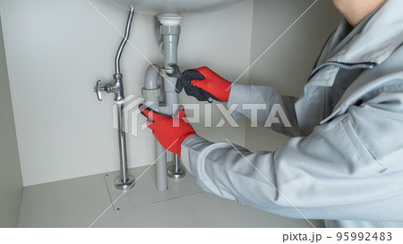 洗面台下の配管修理イメージ｜スパナを持った作業員 95992483