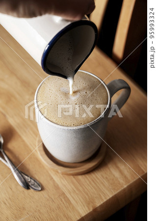 Coffee cup. Pouring milk in coffee mug, morning hot drink. Lifestyle drink photo 95993324