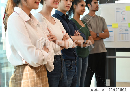 Successful business team standing with crossed arms in start up office. Cropped shot 95993661