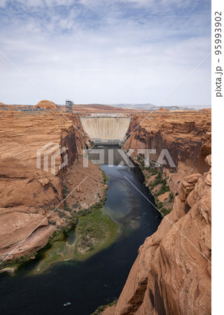 Aerial View Of Glen Canyon Dam And Colorado River Amidst Majestic Canyons Against Cloudy Sky In Arizona During Summer 95993902