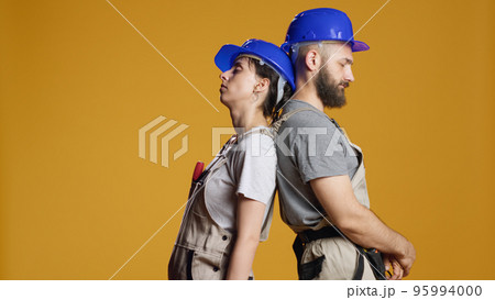 Sleepy builders falling asleep at rebuilding job, trying to work on construction refurbishment and demolition. Tired exhausted contractors feeling overworked, building redevelopment. 95994000