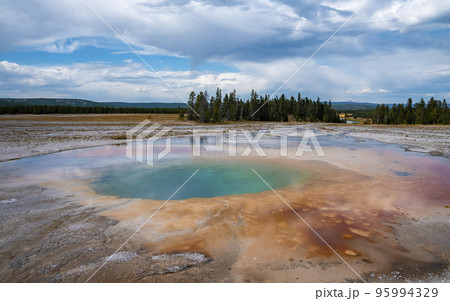 Scenic view of beautiful Grand Prismatic Spring with cloudy sky in background. Geothermal landscape in Midway Geyser Basin during summer. Famous tourist attraction at Yellowstone national park. 95994329