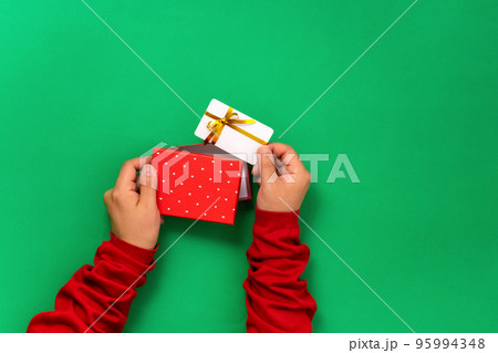 Female hands take out a bonus or gift bank card template from gift box Female hands take out a bonus or gift bank card template from gift box 95994348
