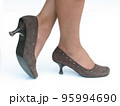 Female feet in the brown suede shoes on a white background 95994690