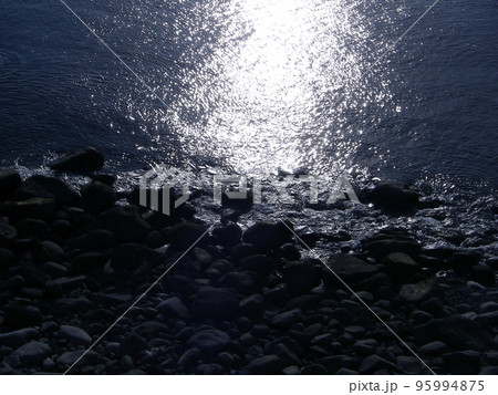 穏やかな波打ち際、逆光に輝くモノトーンな西伊豆のゴロタ浜の風景。 穏やかな波打ち際、逆光に輝くモノトーンな西伊豆のゴロタ浜の風景。 95994875