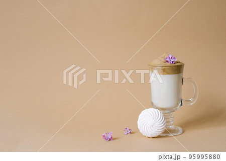Beautiful dalgon coffee drink with foam in a transparent Cup and marshmallows on a beige background. Copy space Beautiful dalgon coffee drink with foam in a transparent Cup and marshmallows on a beige background. Copy space 95995880