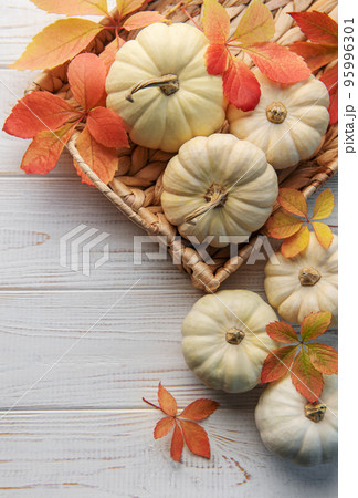 Autumn leaves and pumpkins over old wooden background Autumn leaves and pumpkins over old wooden background 95996301