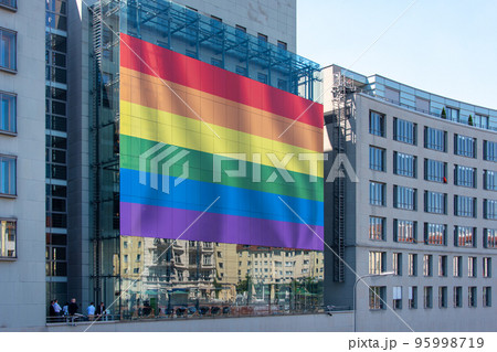Giant LGBT flag on the huge screen on the building wall. Pride Flag, rainbow flag of the LGBT community. Minorities, protection and equality concept, pride month in a city. Giant LGBT flag on the huge screen on the building wall. Pride Flag, rainbow flag of the LGBT community. Minorities, protection and equality concept, pride month in a city. 95998719