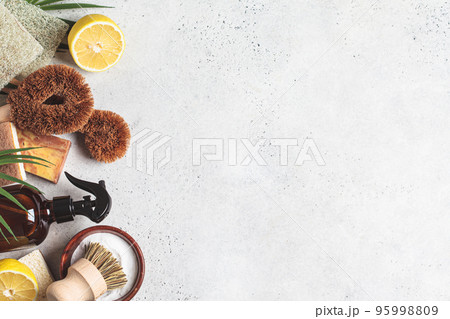 Zero waste eco friendly products and tools for house cleaning. Wooden brushes, coconut sponges, spray vinegar, soda, lemon and organic soap, gray background. Zero waste eco friendly products and tools for house cleaning. Wooden brushes, coconut sponges, spray vinegar, soda, lemon and organic soap, gray background. 95998809