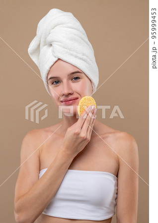 Cute young girl cleansing her face with toner Cute young girl cleansing her face with toner 95999453