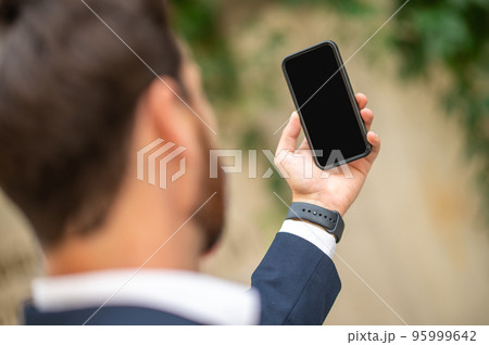 Man holding a smartphone in hand 95999642