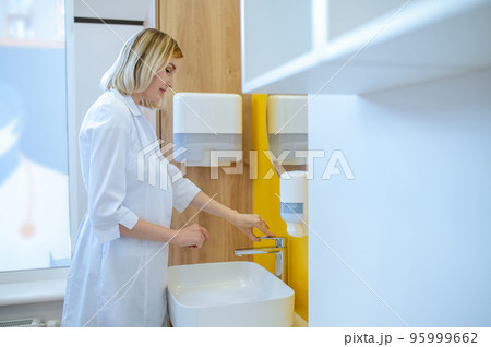 Female doctor washing hands in the bathroom 95999662