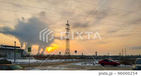 Industrial landscape. Red car and power lines against the backdrop of sunset and smoke from the chimneys of a thermal power plant 96000254
