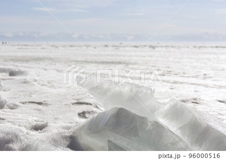Transparent blue ice hummocks on lake Baikal shore. Siberia winter landscape view. Snow-covered ice of the lake 96000516