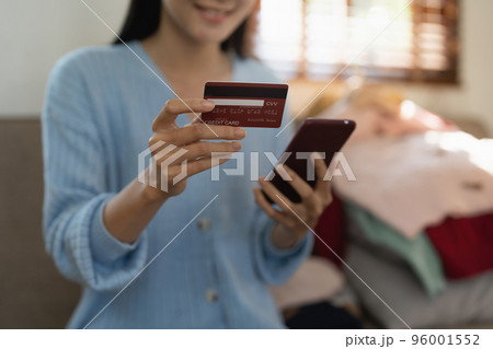 Young person using credit card and laptop computer. Online shopping, e-commerce concept 96001552