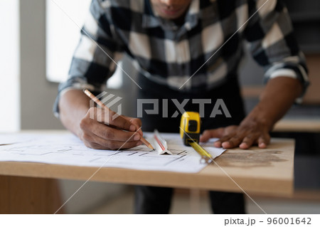 Architect man working with blueprints for architectural plan, engineer sketching a construction project, green energy concept 96001642