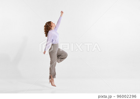 Portrait of young woman reaching top isolated over white studio background. Growing professional ambitions 96002296