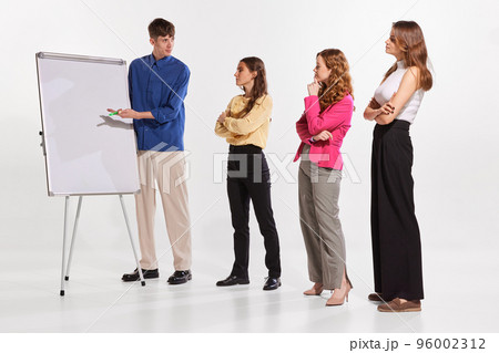 Portrait of young man, coach, mentor, teacher having offline lesson with trainees. Taining courses 96002312