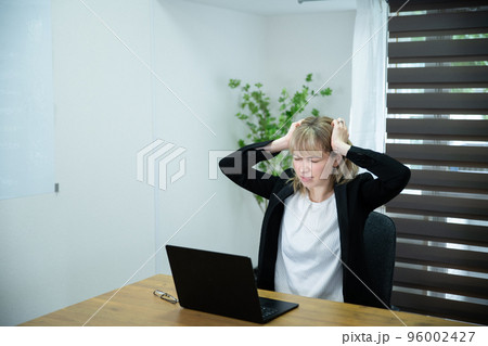 オフィスで働くパソコンを見てストレスを感じている女性 オフィスで働くパソコンを見てストレスを感じている女性 96002427