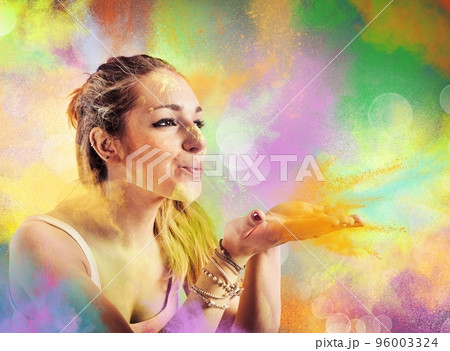 Girl blowing colored powders Girl blowing colored powders 96003324