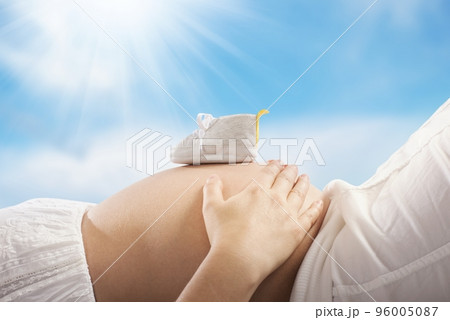 Pregnant woman touching her belly 96005087