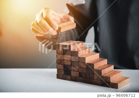 Business hand arranging put wooden block stacking step stair growth success process, financial risk management and strategic plan and business challenge planning concept, prevent collapse or crash 96006712