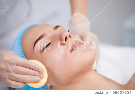 beautician cleanses skin of beautiful woman with a sponge. beautician cleanses skin of beautiful woman with a sponge. 96007654