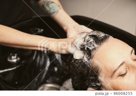 Womens fashion and style. Hair care, beauty industry concept. Hairdresser washing client hair 96008255