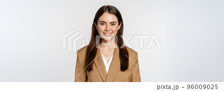 Portrait of business woman with enthusiastic face expression, smiling, looking confident, standing in suit over white background 96009025