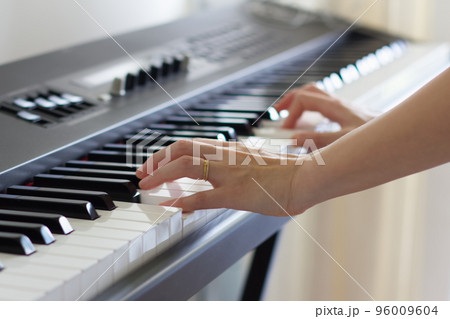 電子ピアノを弾く女性の手元 96009604