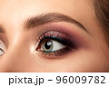 Closeup of green woman eye with smokey eyes makeup 96009782