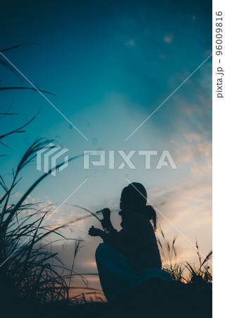 夕暮れの自然の中で佇む女性のシルエット写真 夕暮れの自然の中で佇む女性のシルエット写真 96009816