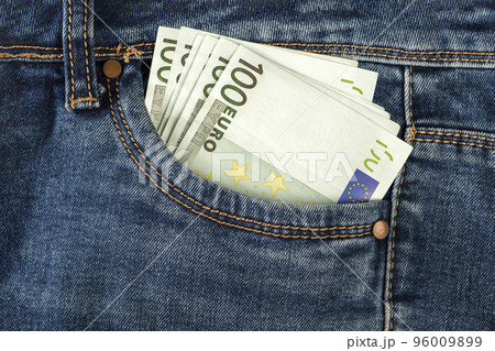 A stack of 100 euro bills in a jeans pocket. Money in the front pocket of jeans. The concept of investment, cash, wealth and profit, copyspace. 96009899