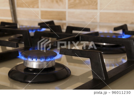 Closeup shot of blue fire from domestic kitchen stove. Gas cooker with burning flames propane gas. 96011230