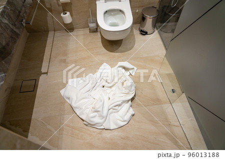 Crumpled used towel on the bathroom floor Crumpled used towel on the bathroom floor 96013188