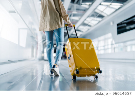 International airport terminal. Asian beautiful woman with luggage and walking in airport International airport terminal. Asian beautiful woman with luggage and walking in airport 96014657
