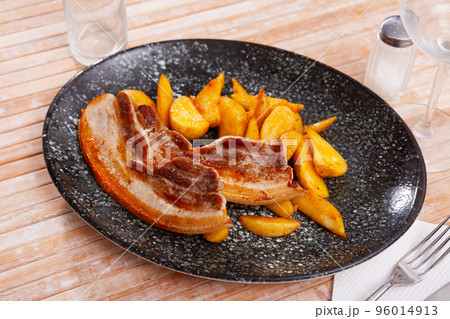 Roasted pork side bacon served with fried potato Roasted pork side bacon served with fried potato 96014913