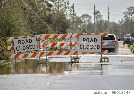 Road closed for roadworks and danger of flooding with warning signs blocking driving of cars 96015547