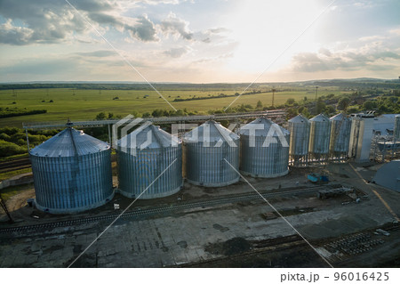 Aerial view of industrial ventilated silos for long term storage of grain and oilseed. Metal elevator for wheat drying in agricultural zone Aerial view of industrial ventilated silos for long term storage of grain and oilseed. Metal elevator for wheat drying in agricultural zone 96016425